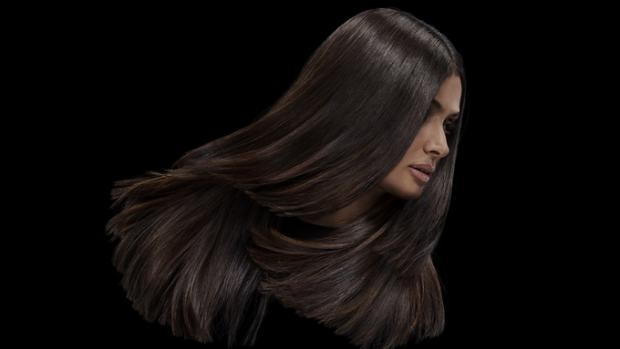 Uzun, hacimli, parlak kahverengi saçlara sahip bir model.