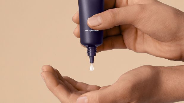 Dyson Chitosan Pre-style cream squeezed into the hand.