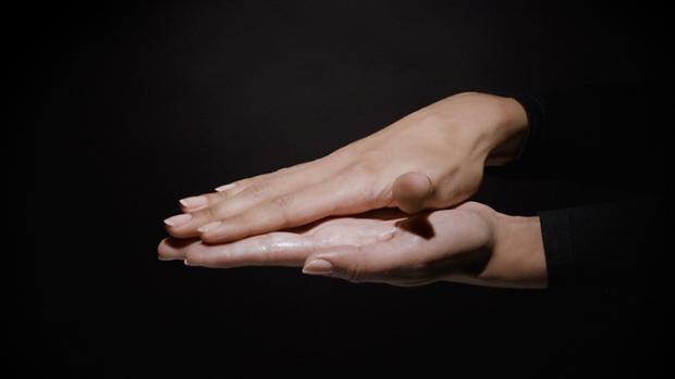 Two hands rub product between the palms.