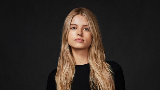 Model with long, straight, fine hair, against a dark background.