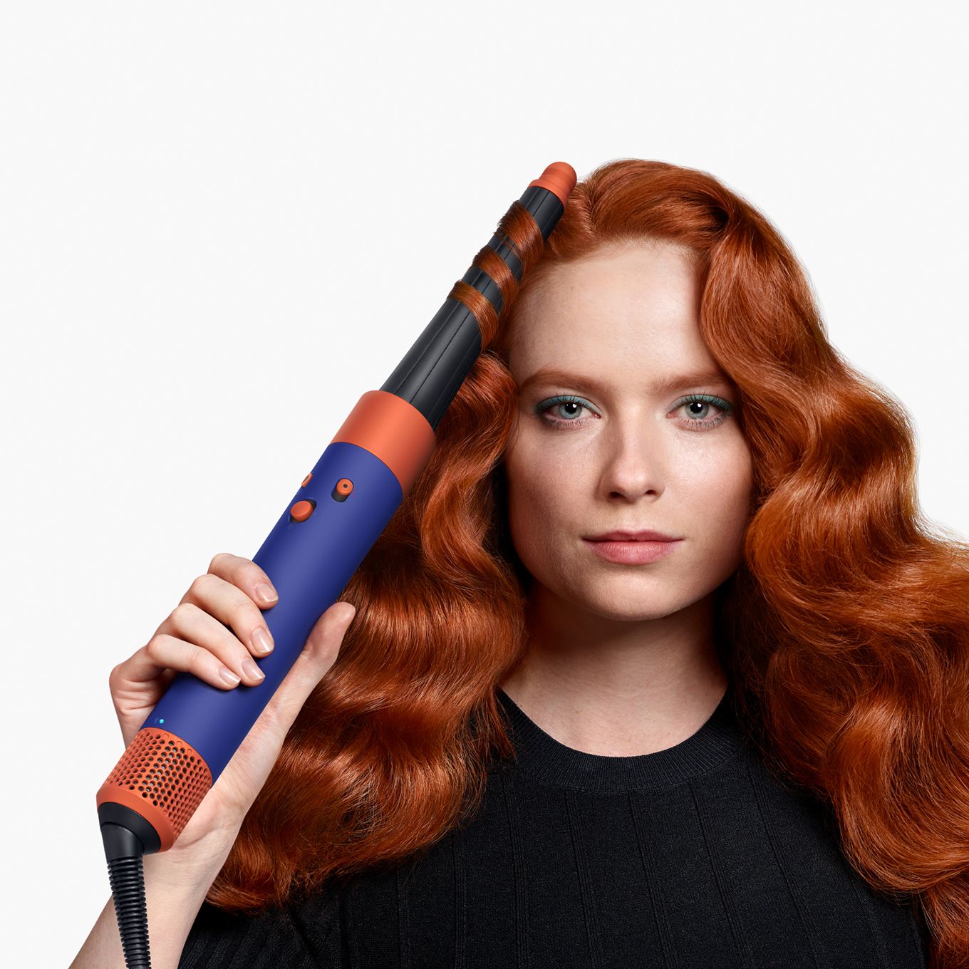 A model styles her hair with a Dyson Airwrap ID multi-styler and dryer.