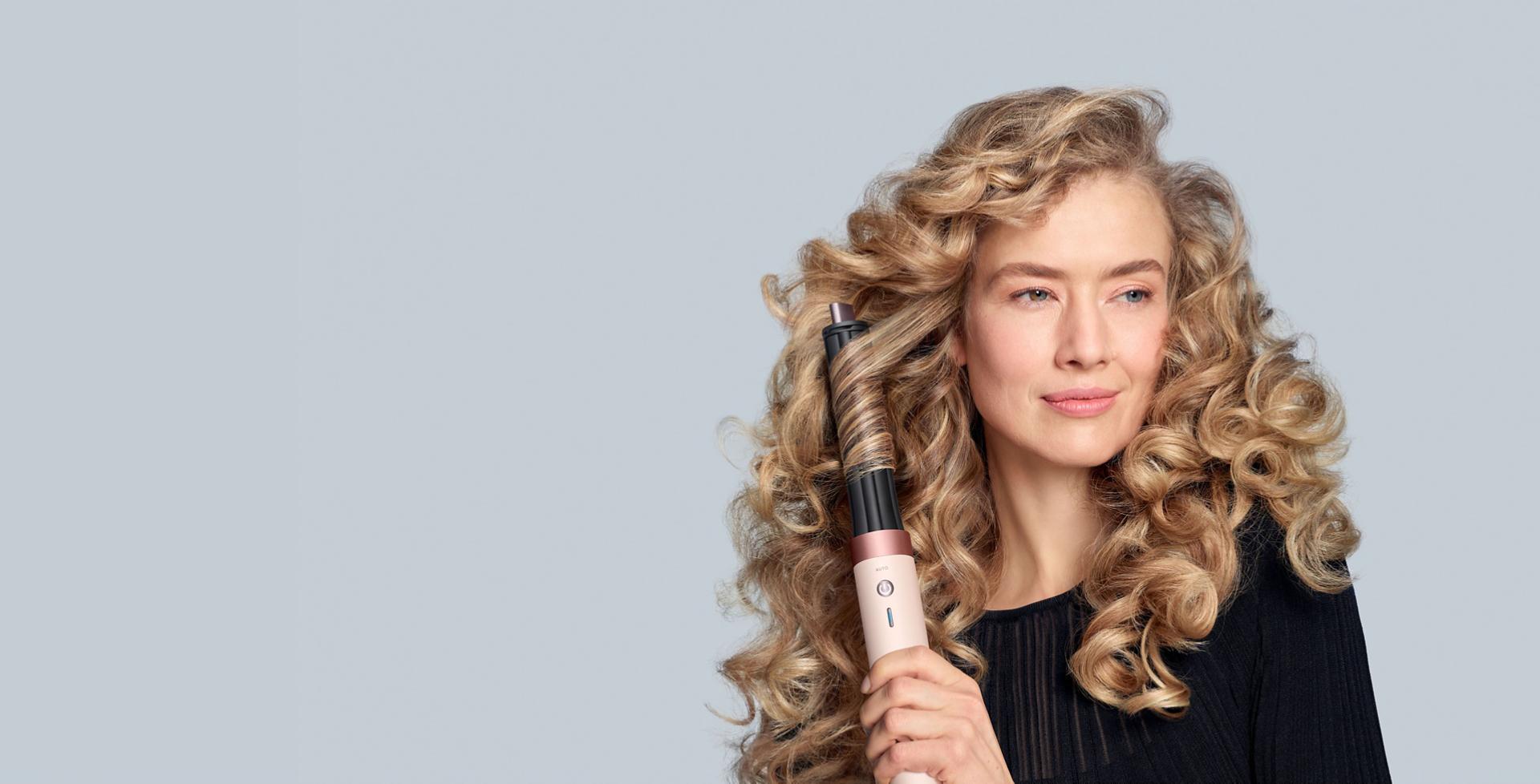 Multiestilizador y secadora Dyson Airwrap Co-anda2x con estilizador Co-anda2x de 30 mm utilizado por una modelo rubia para rizar el cabello.