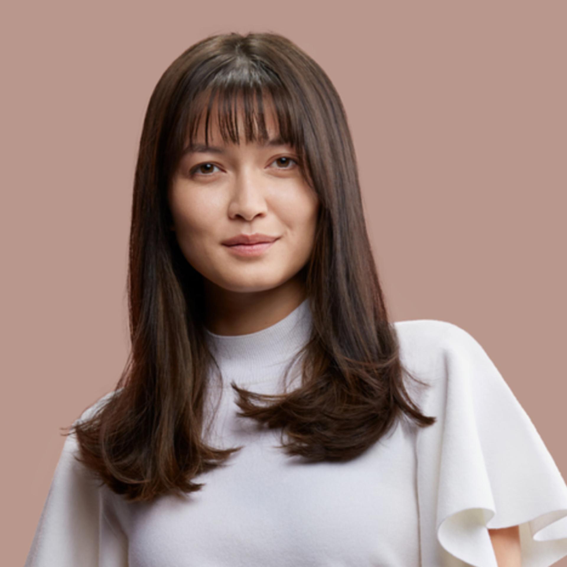 A model with dark hair styled with the Dyson Supersonic r hair dryer.