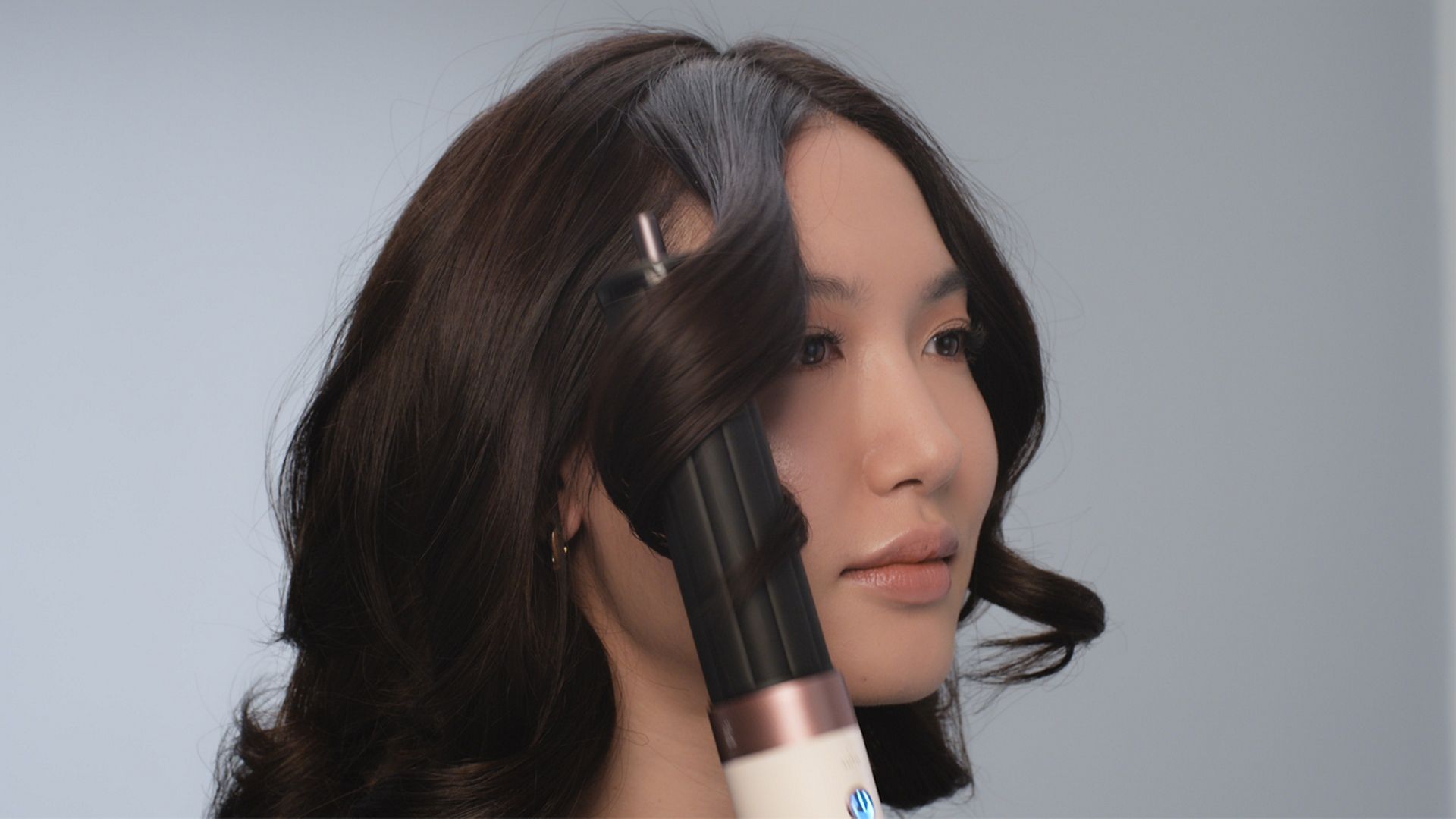 مجفف ومصفف Dyson Airwrap Co-anda2x متعدد الوظائف بينما يُستخدَم لتصفيف شعر عارِضة.