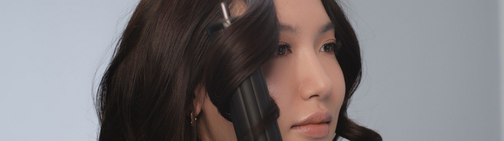 مجفف ومصفف Dyson Airwrap Co-anda2x متعدد الوظائف بينما يُستخدَم لتصفيف شعر عارِضة.