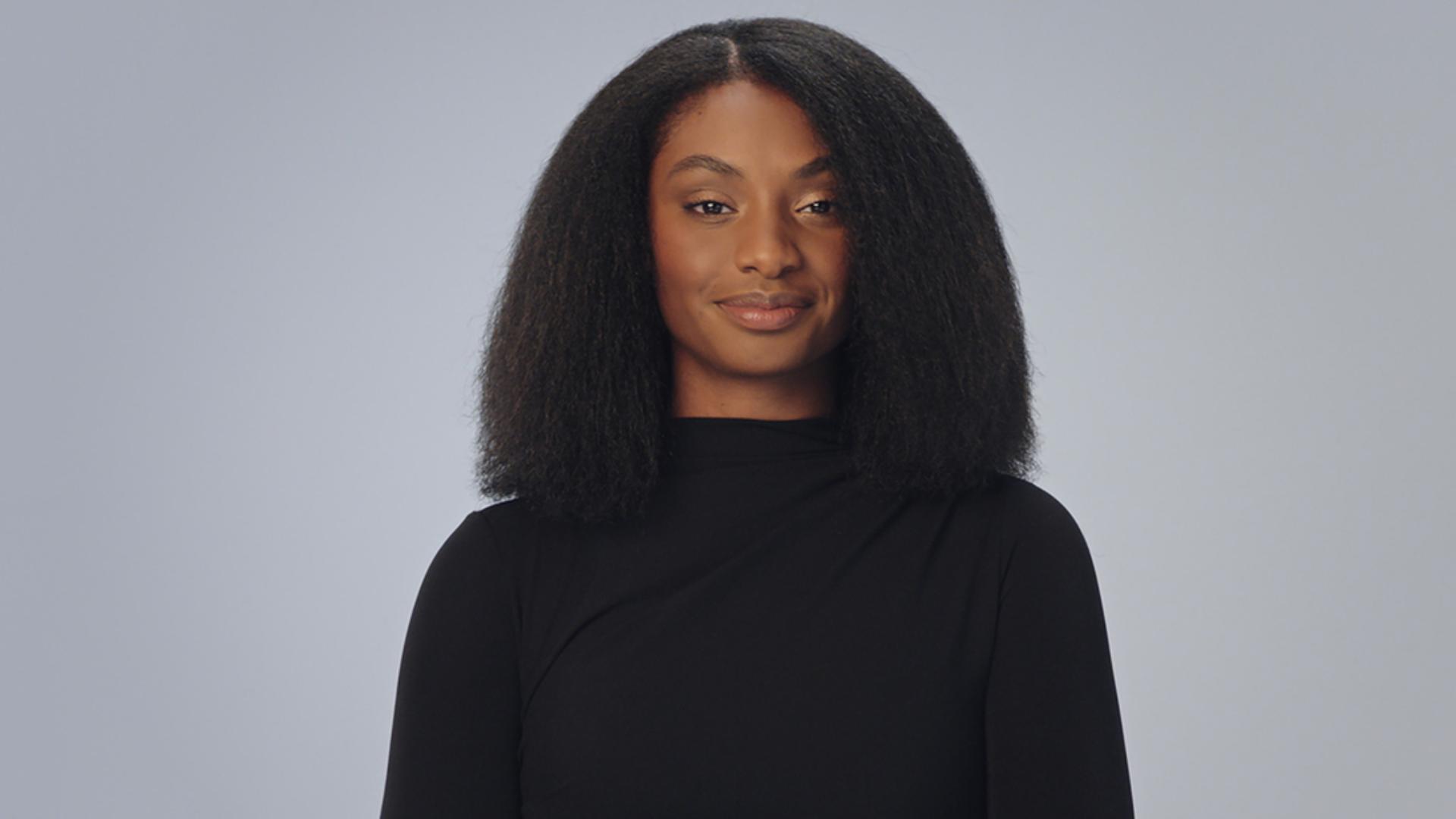 นางแบบผมสีเข้มหยิกเป็นขดที่ยืดออกให้เป็นสไตล์แบบเก็บผมมิดชิด