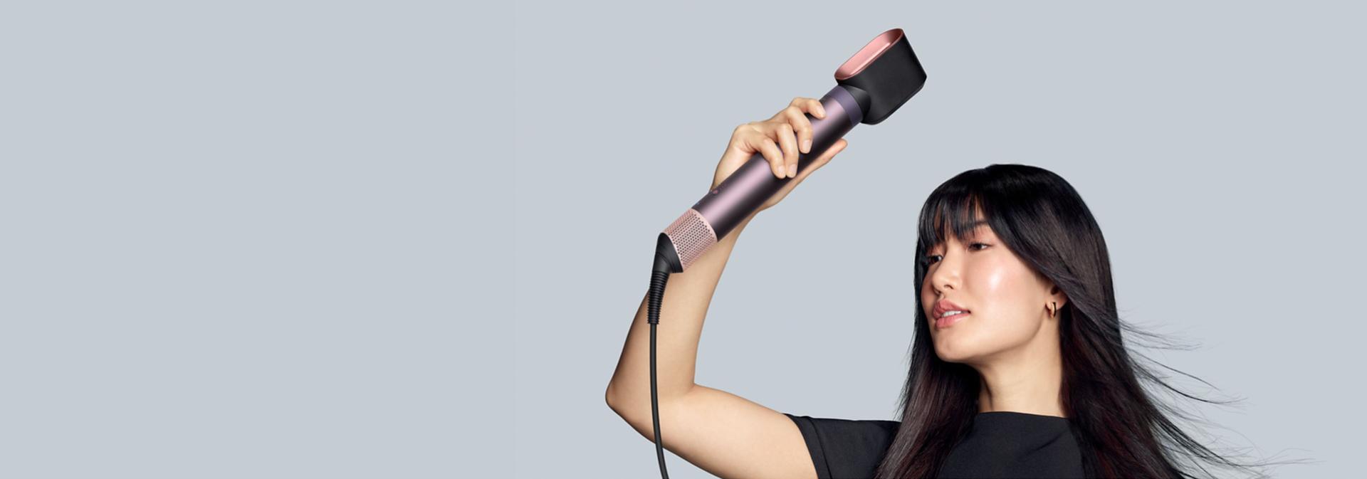 The Dyson Airwrap Co-anda2x multi-styler and dryer with the Fast dryer 2x used by a dark-haired model to dry her long hair.
