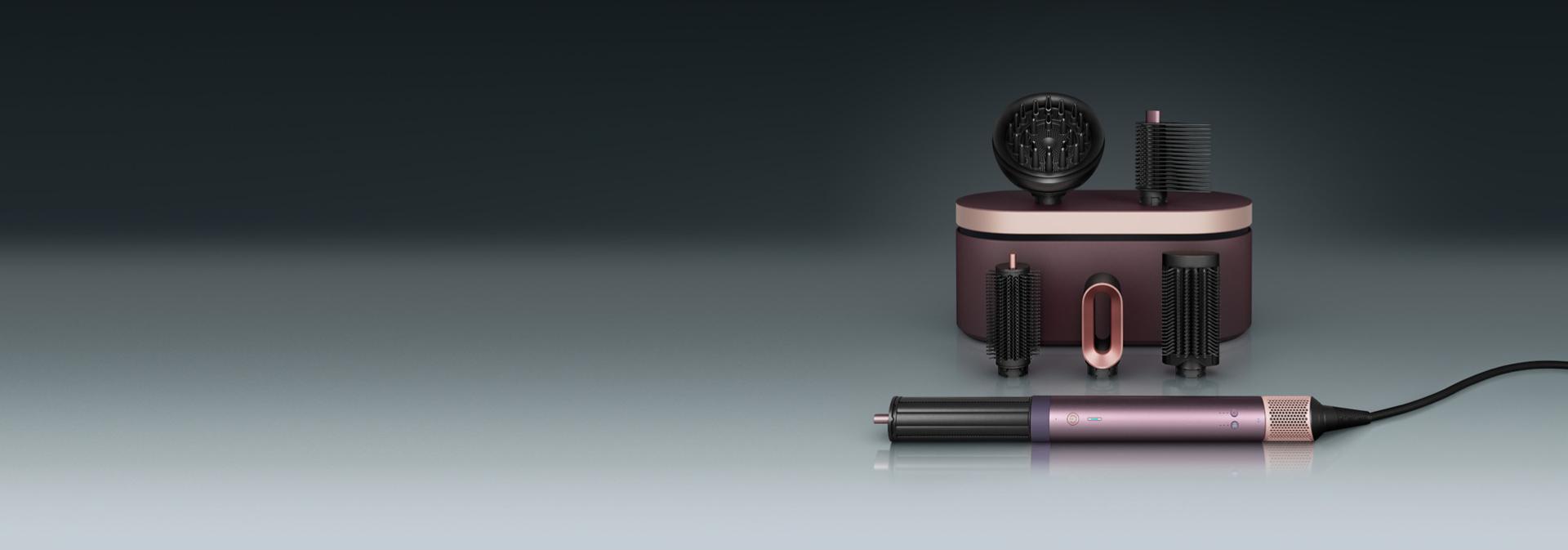 Multistyler Dyson Airwrap Co-anda2x leży przed etui ochronnym z szeregiem kocówek.