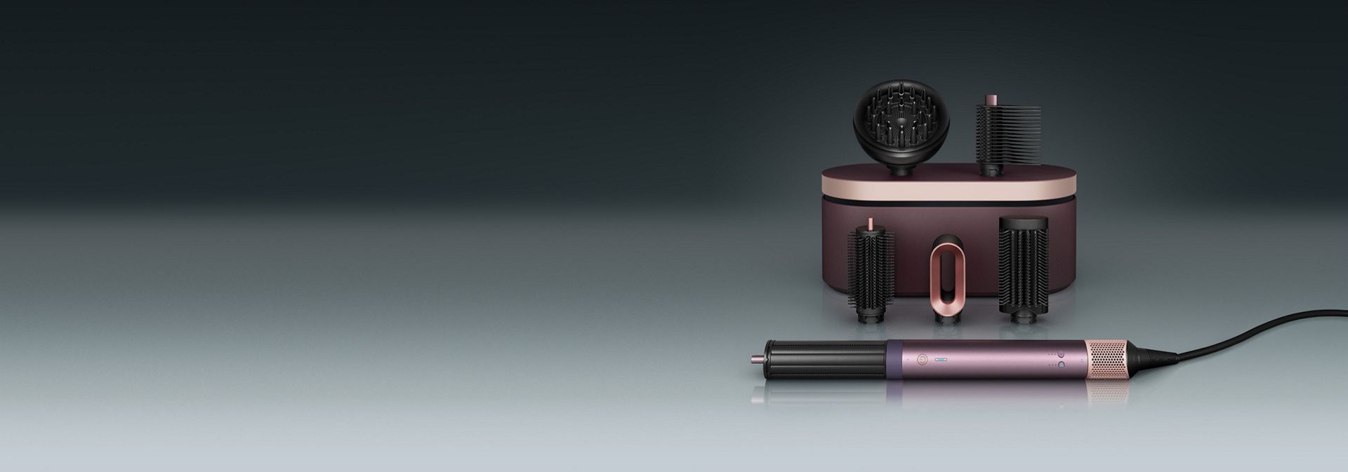 Multistyler Dyson Airwrap Co-anda2x leży przed etui ochronnym z szeregiem kocówek.