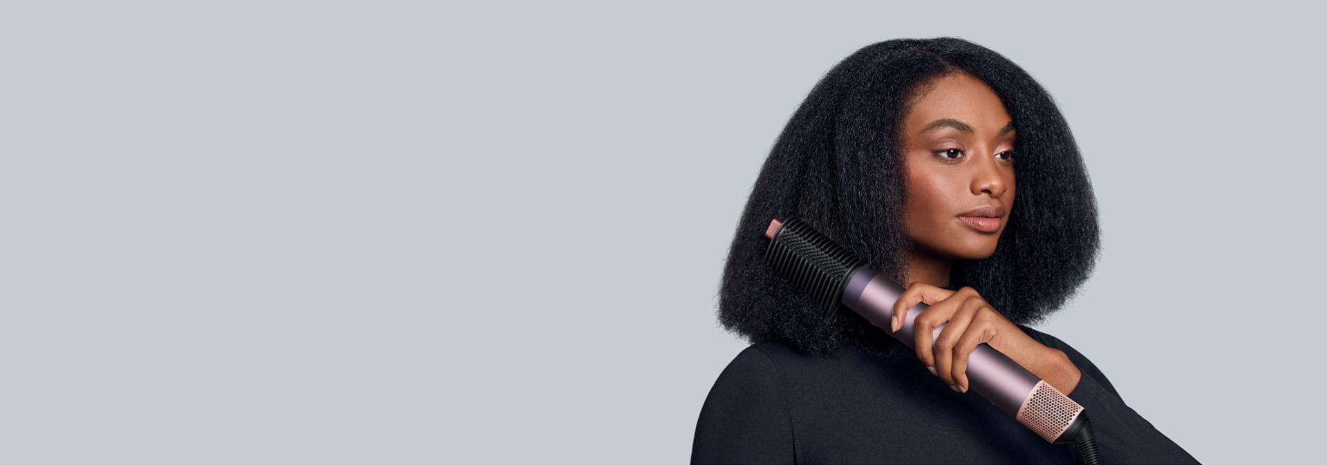 Multistyler Dyson Airwrap Co-anda2x z nowym grzebieniem napinającym włosy używany przez modelkę.