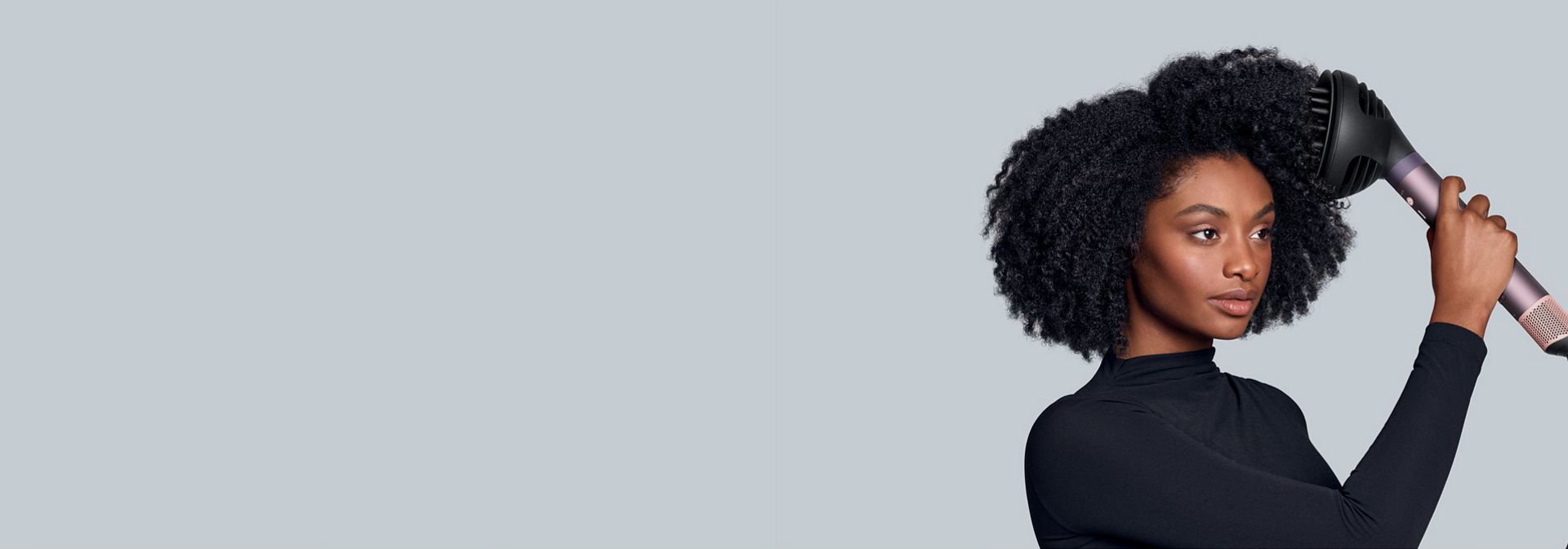 Modelka stylizuje włosy za pomocą multistylera Dyson Airwrap Co-anda2x oraz dyfuzora Wave+Curl 2x.