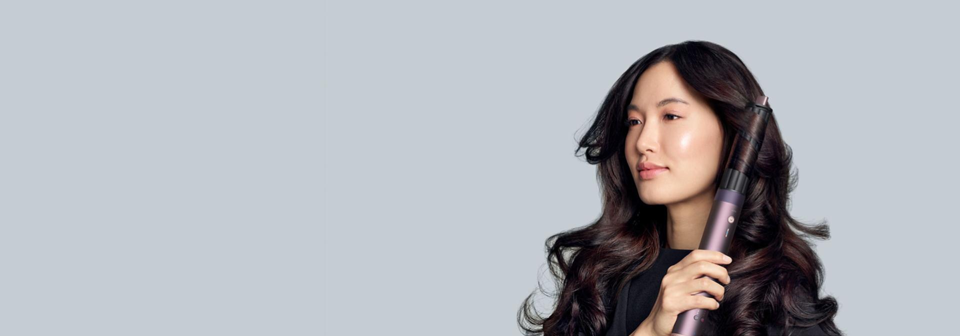 The Dyson Airwrap Co-anda2x multi-styler and dryer with the 40mm Co-anda2x curling barrel used by a model.