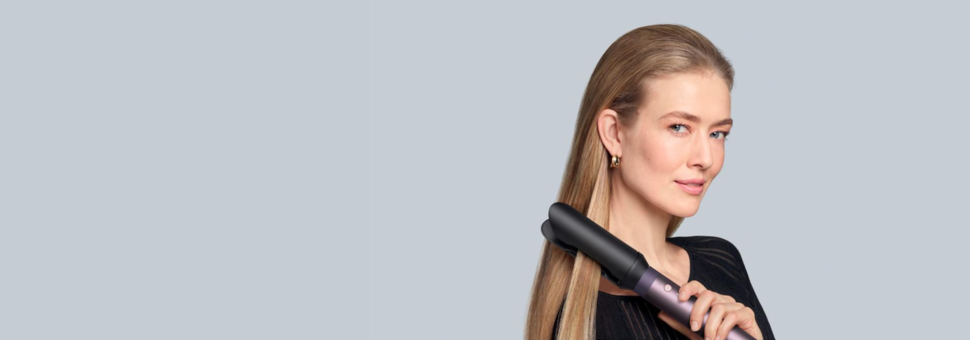 The Dyson Airwrap Co-anda2x multi-styler and dryer with the Airsmooth2x attachment used by a model.