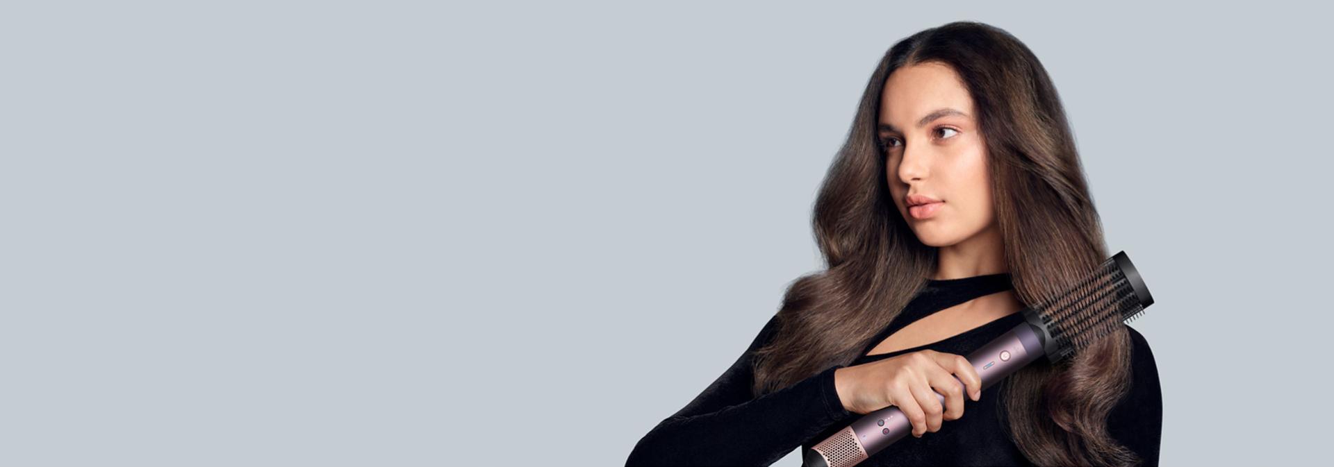 The Dyson Airwrap Co-anda2x multi-styler and dryer with the Anti-snag loop brush 2x attachment used by a model.