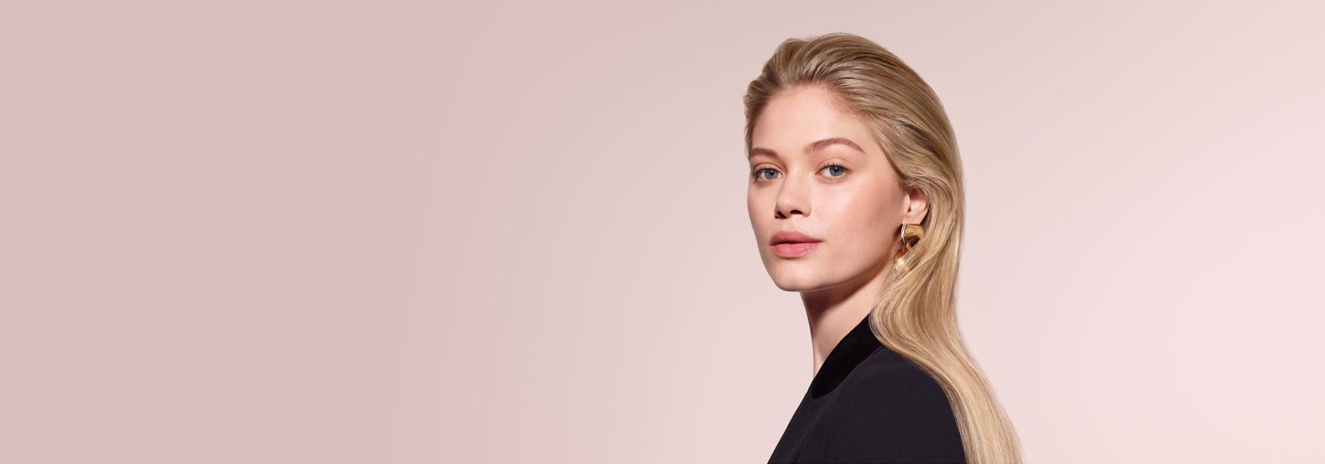 A model with blonde hair styled using the Dyson Airwrap Co-anda2x multi-styler and dryer with the Airsmooth2x attachment.