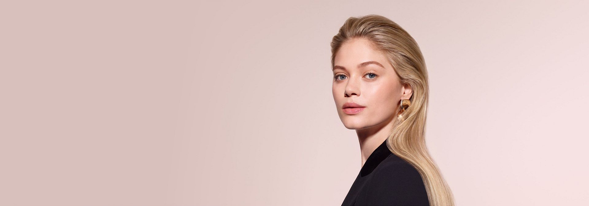 A model with blonde hair styled using the Dyson Airwrap Co-anda2x multi-styler and dryer with the Airsmooth2x attachment.