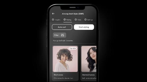Tālruņa ekrāns, kurā redzamas matu ieveidošanas pamācības lietotnē My Dyson.