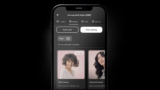 Tālruņa ekrāns, kurā redzamas matu ieveidošanas pamācības lietotnē My Dyson.