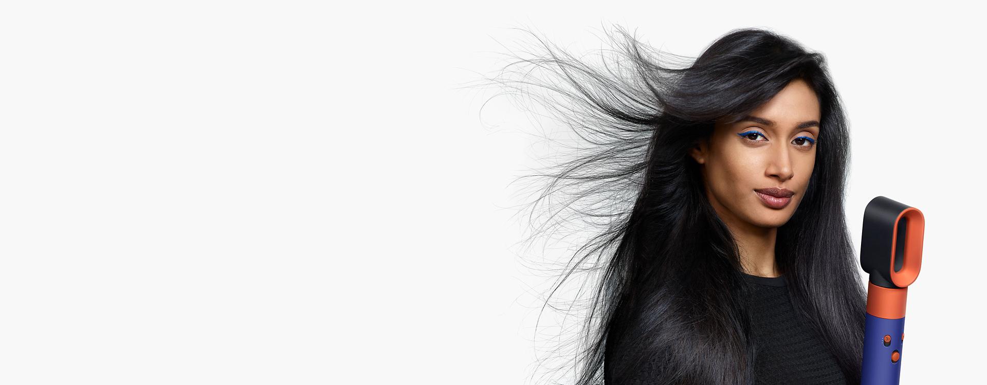 Model using the Fast dryer for the Dyson Airwrap multi-styler and dryer.