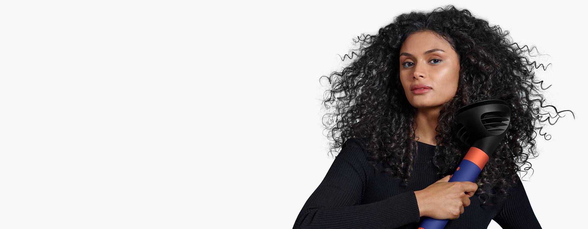 Model using the Wave+Curl diffuser for the Dyson Airwrap multi-styler and dryer.