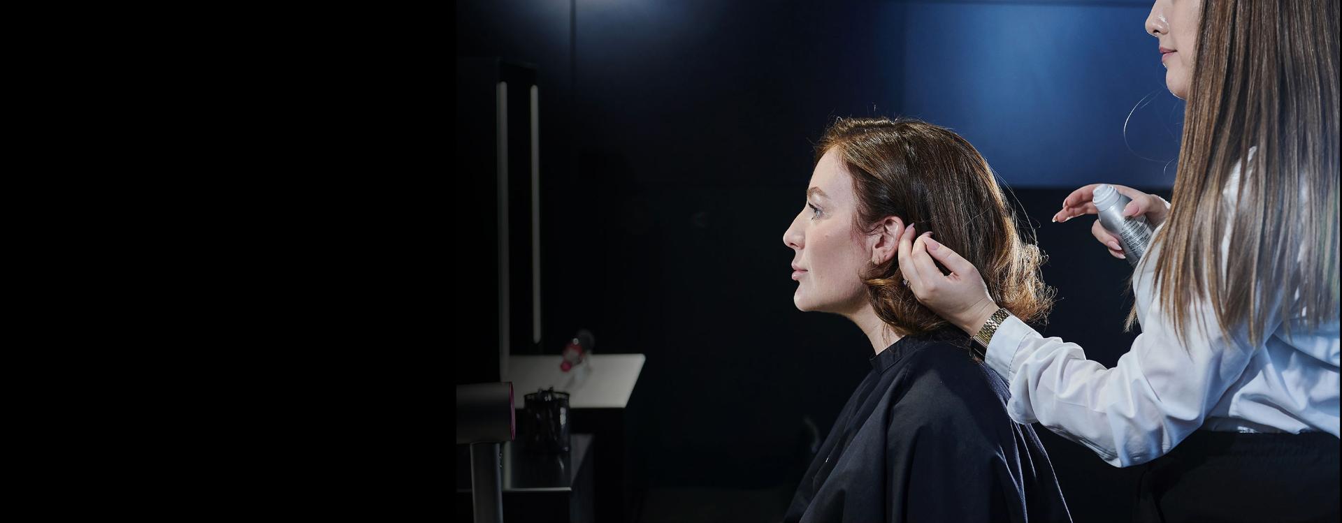 Klientka Dyson cieszy się sesją stylizacyjną w sklepie Dyson