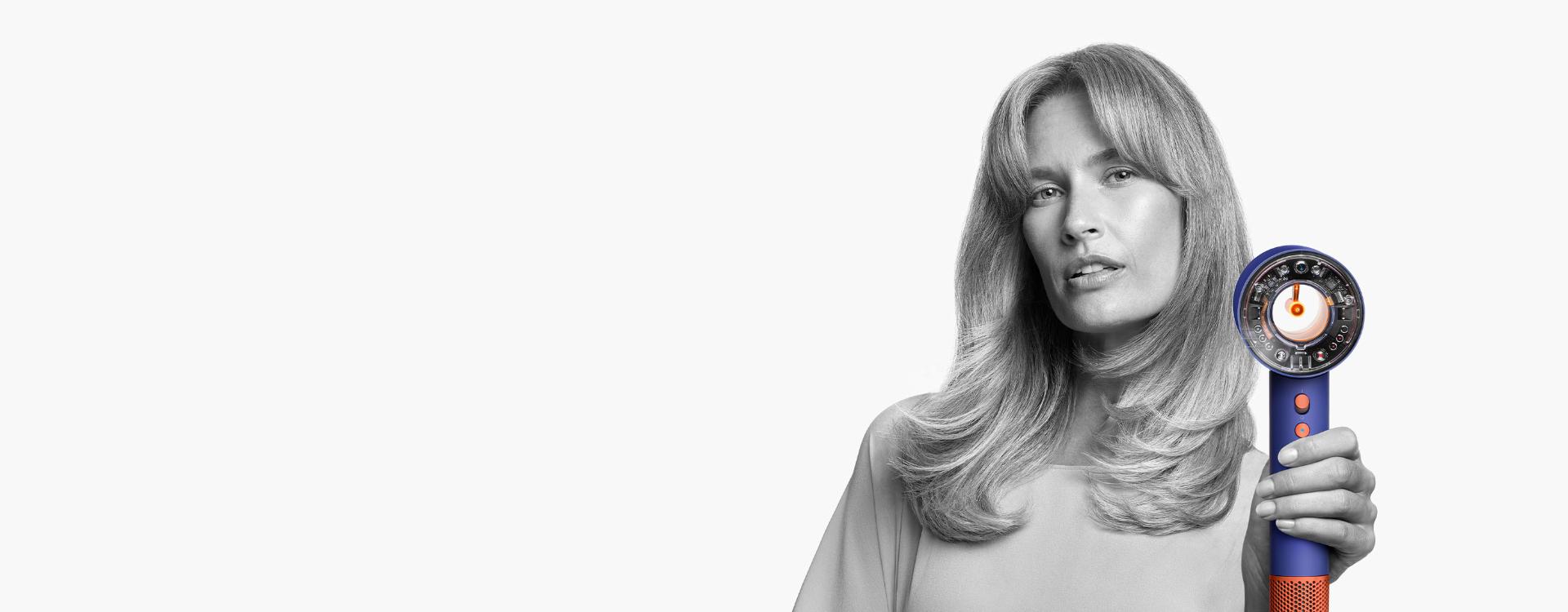 Female model using the Dyson Supersonic Nural hair dryer