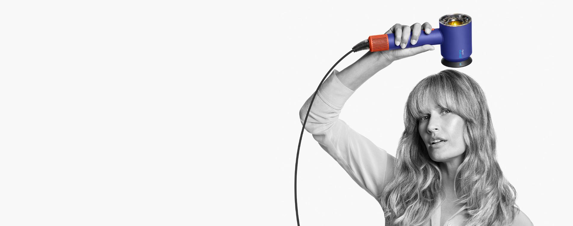 Female model using the Dyson Supersonic Nural hair dryer