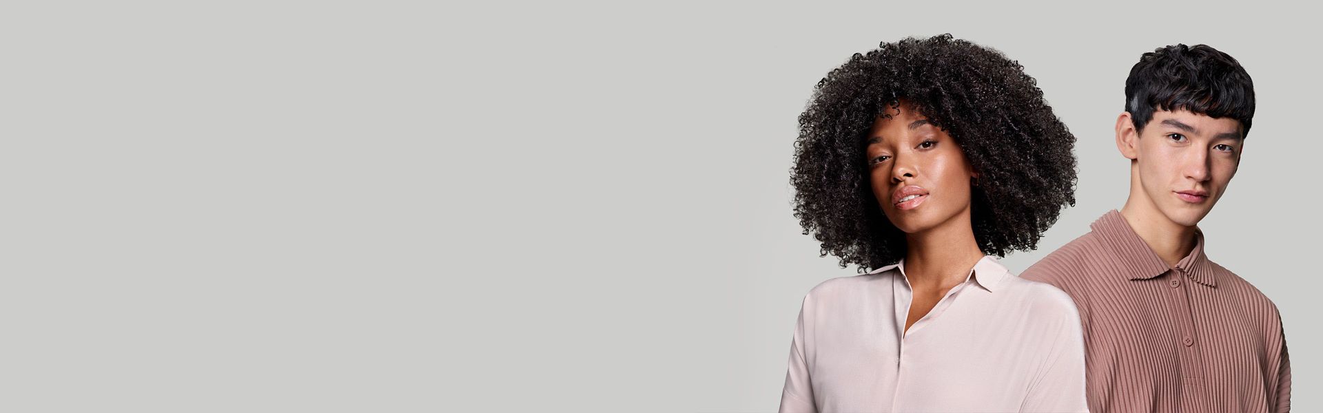 A woman with coily, voluminous hair and a man with short blunt hair.