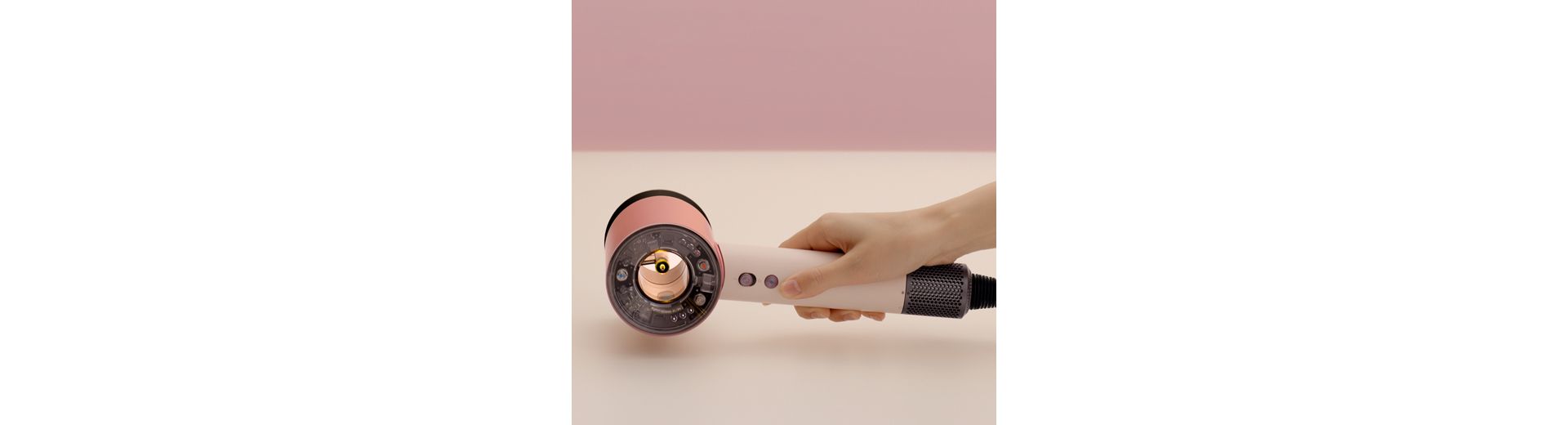 A hand reaching down to pick up the Dyson Supersonic Nural hair dryer.