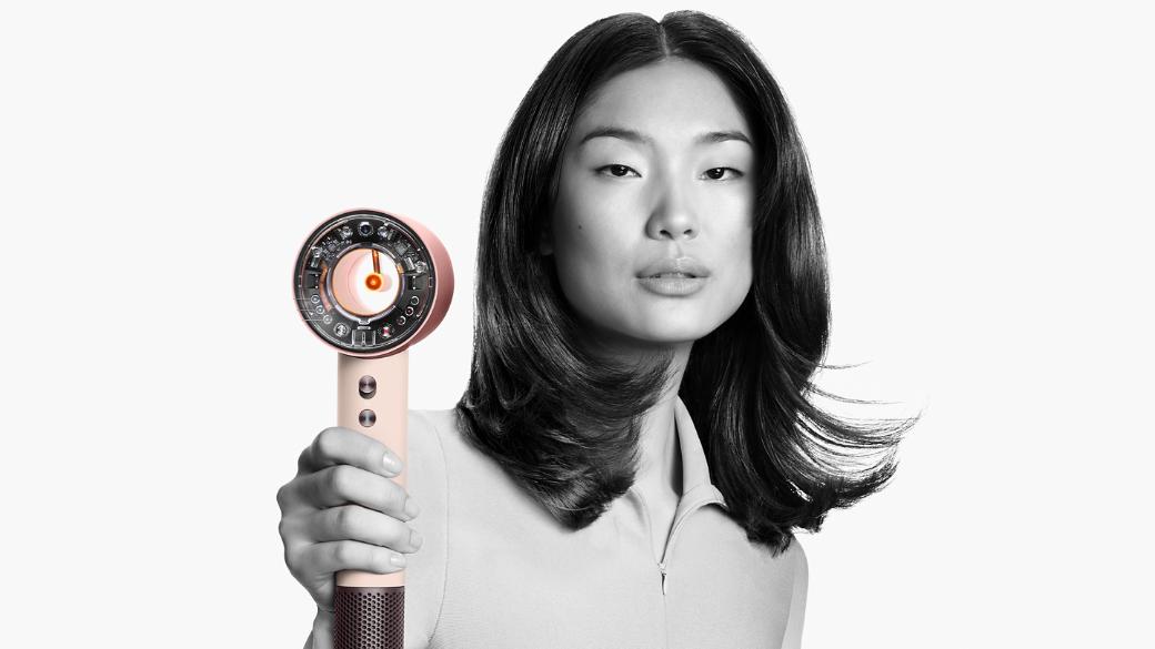 Female model with her hair styled in a blow dry style holding the Dyson Supersonic Nural hair dryer.