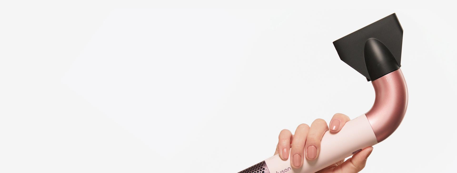 A model holding a Supersonic r hair dryer
