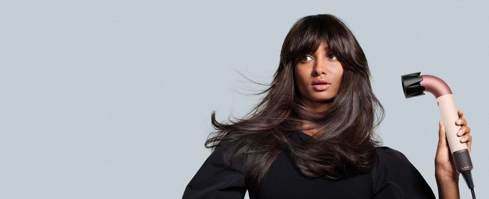 Dyson Supersonic r hair dryer is used by a brunette woman to rough dry her hair.