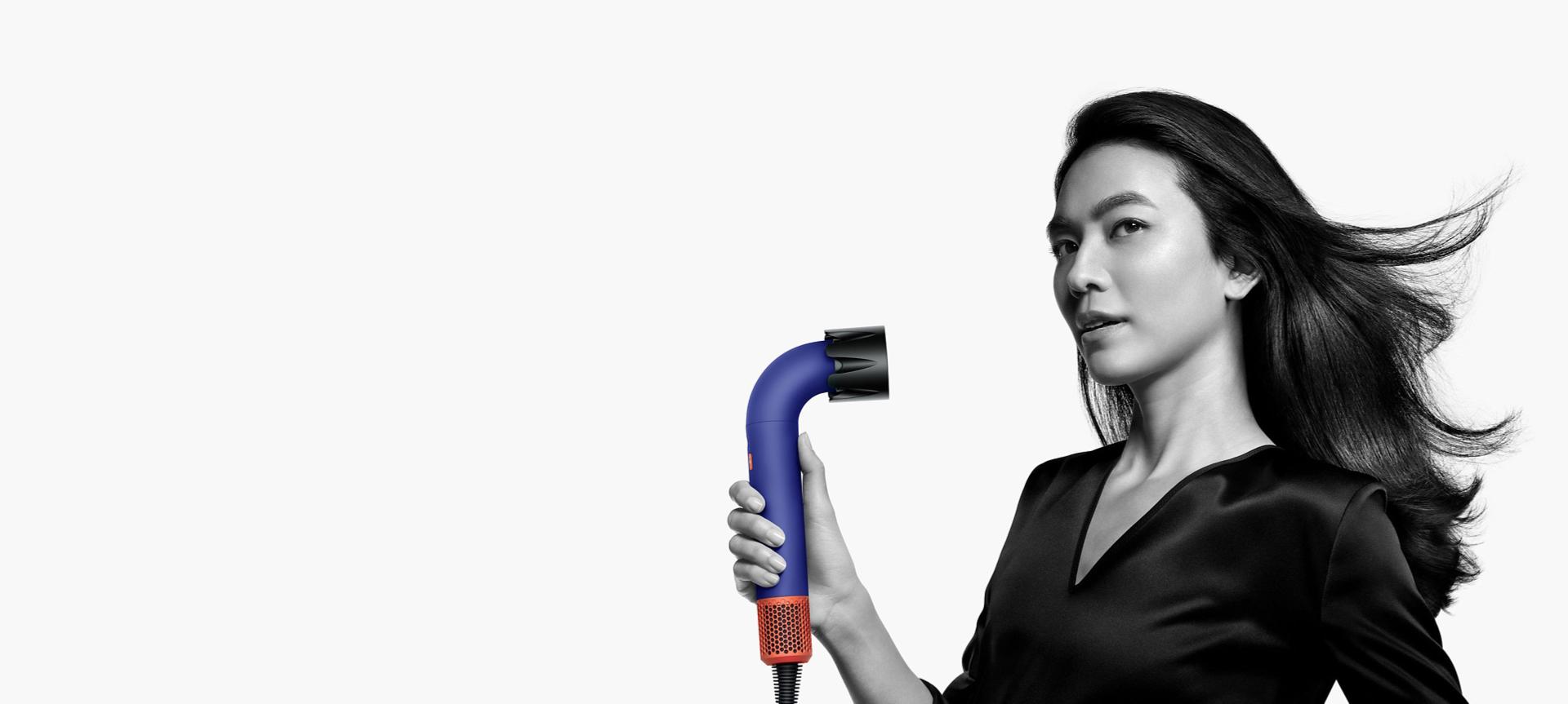 Model using the Dyson Supersonic r hair dryer with the powerful air attachment.