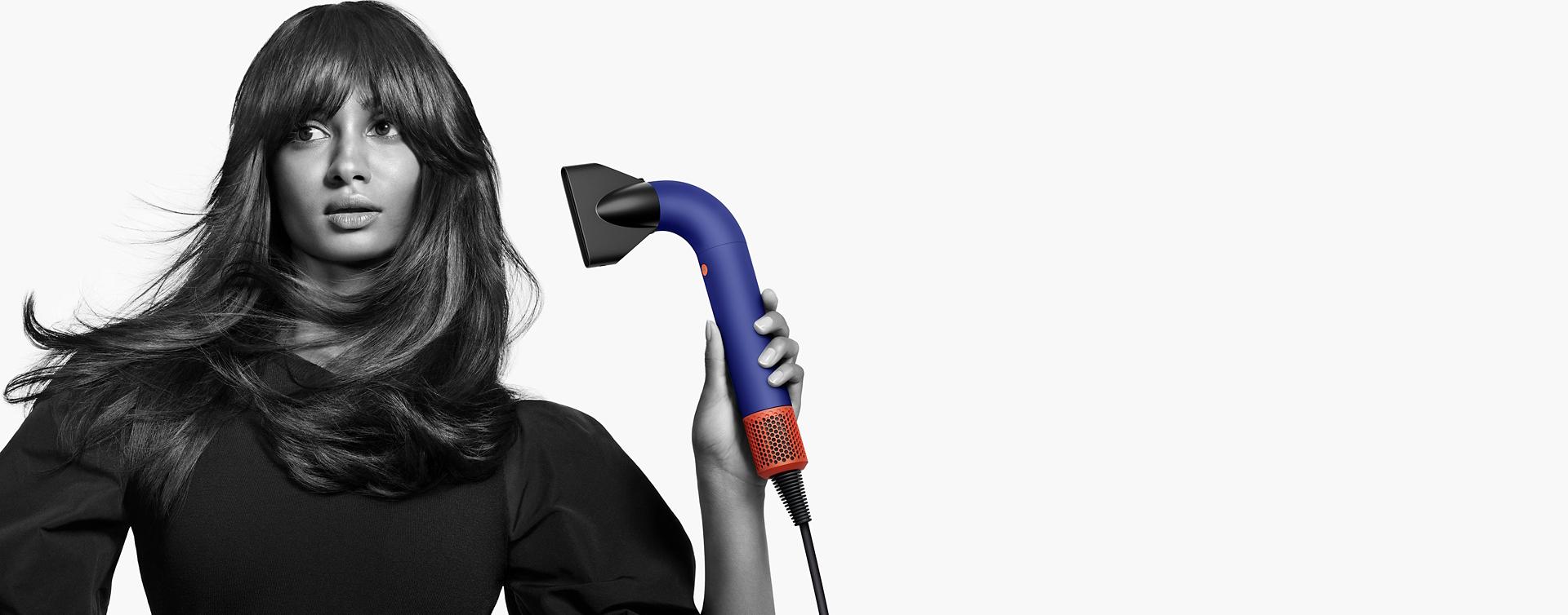 عارضة تستخدم مجفف الشعر Dyson Supersonic r مع ملحق المكثف Pro.