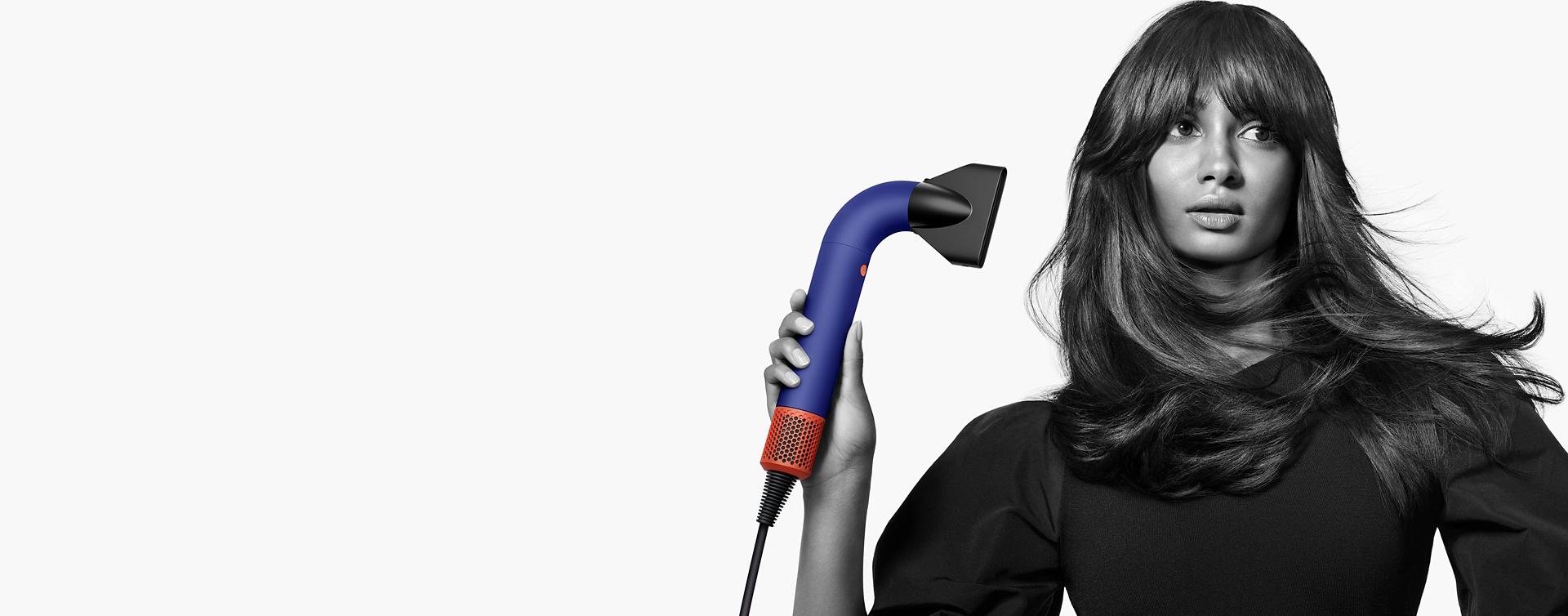 Model using the Dyson Supersonic r hair dryer with the Pro concentrator attachment.
