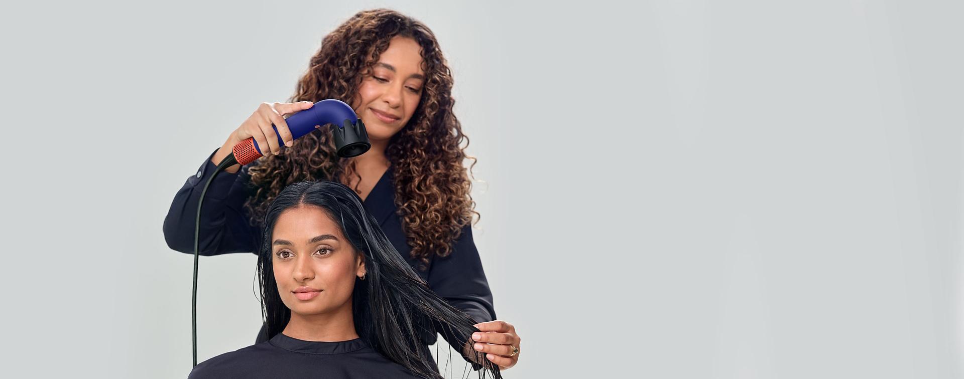 Global Styling Ambassador drying hair of model with Dyson Supersonic r hair dryer and Powerful air attachment.