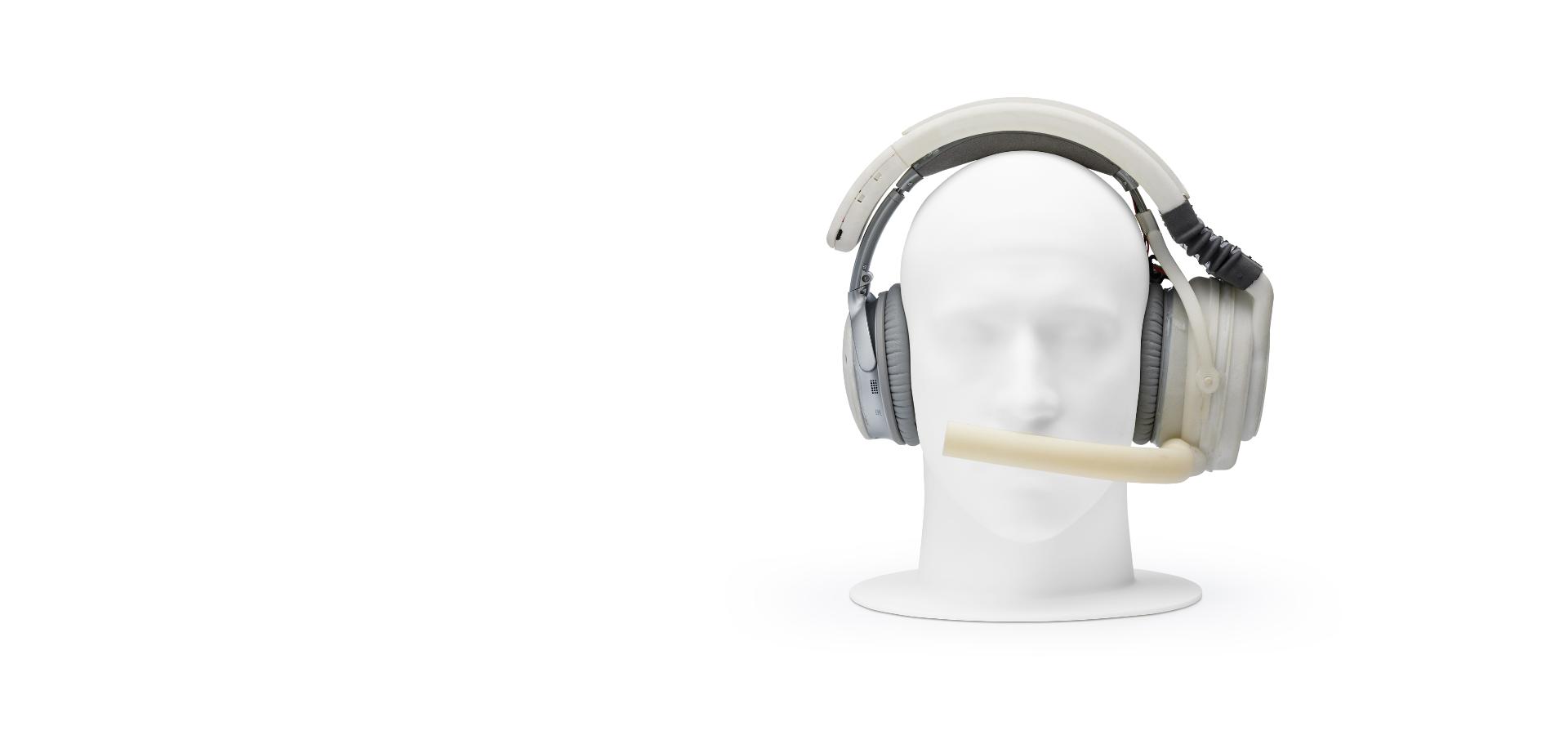 Manikin head wearing prototype headphones, with mouthpiece