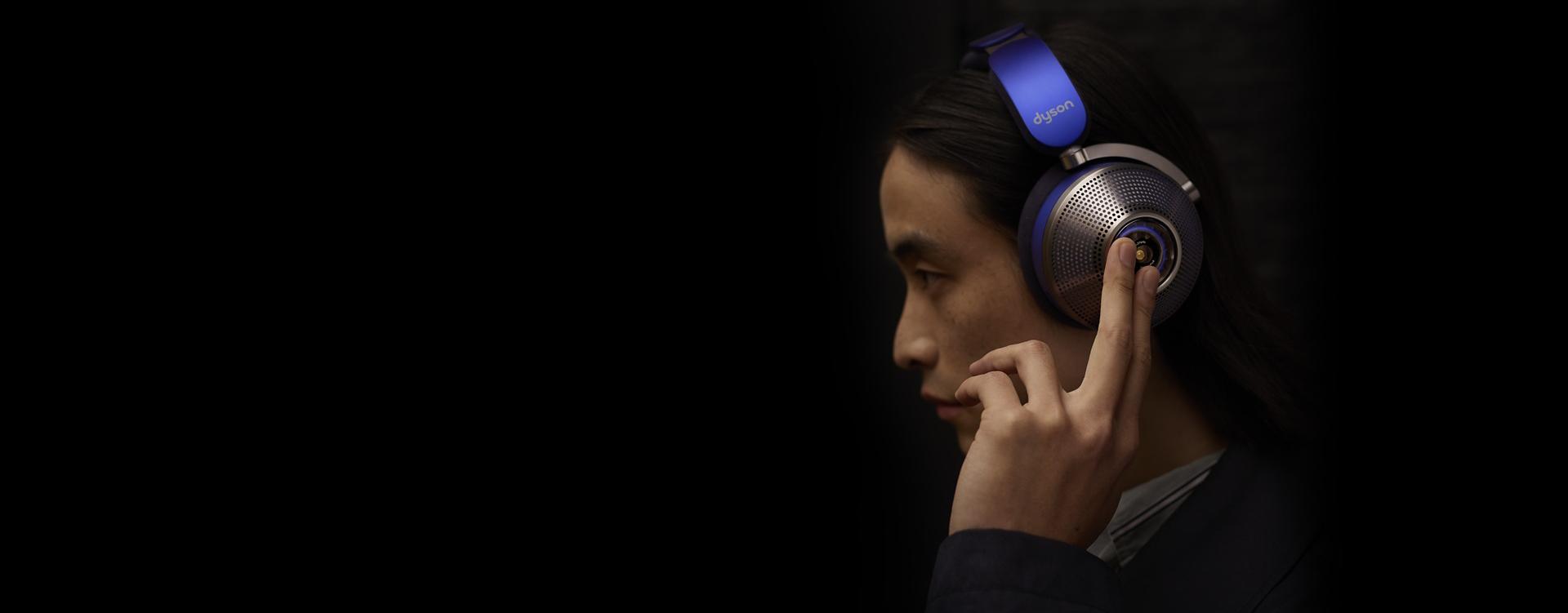 Man looking at camera wearing Dyson zone noise-cancelling headphones.
