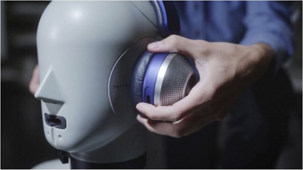 Engineer placing headphones on head of dummy