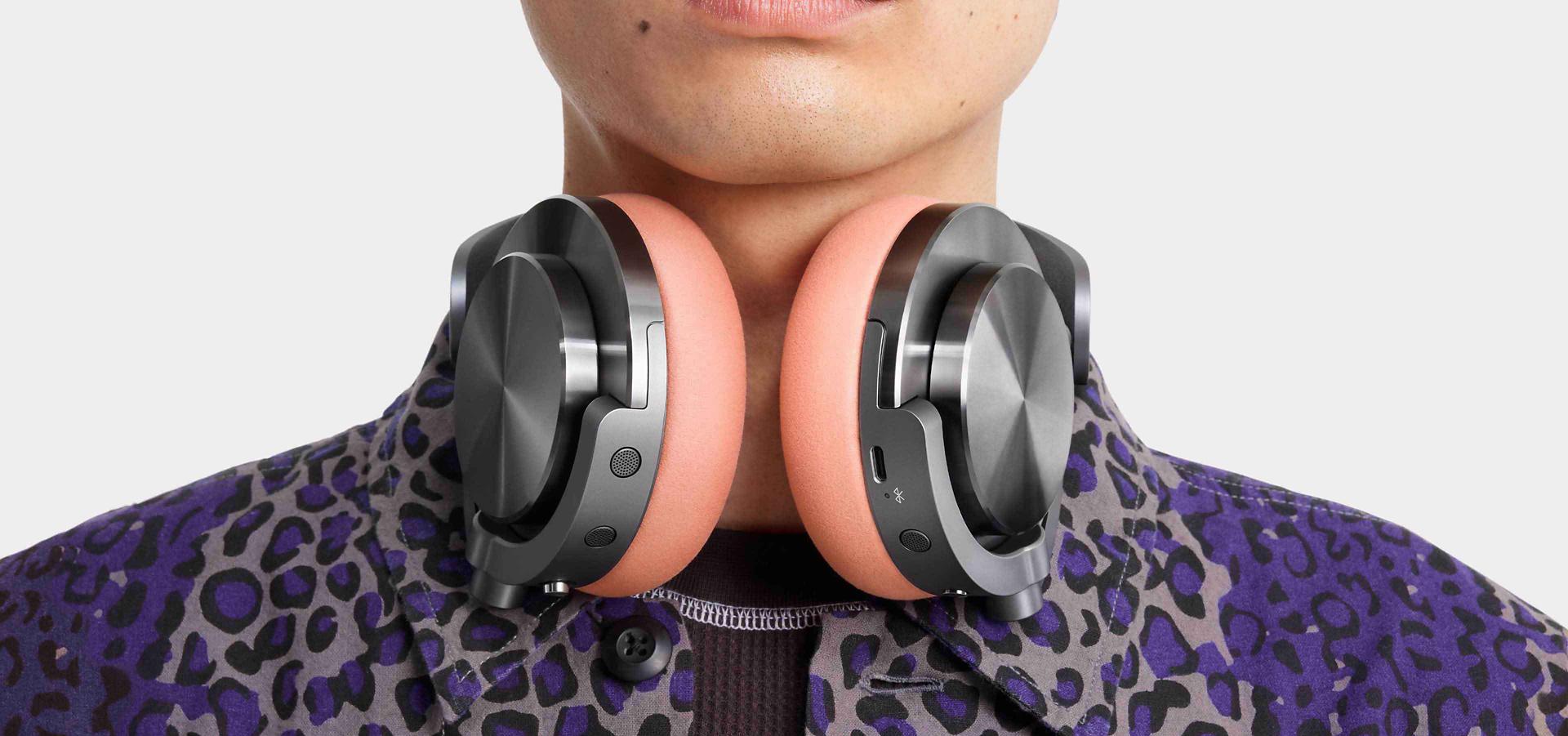 A model wearing Dyson OnTrac headphones around their neck.