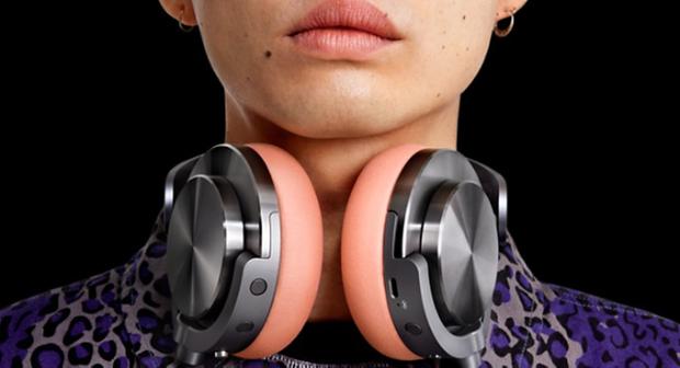 Model with the Dyson Ontrac headphones round their neck, with CNC aluminium caps and Oyster pink cushions.
