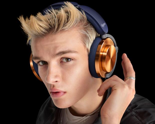 Model with the Dyson Ontrac headphones with CNC Copper caps while he taps them to control the sound.