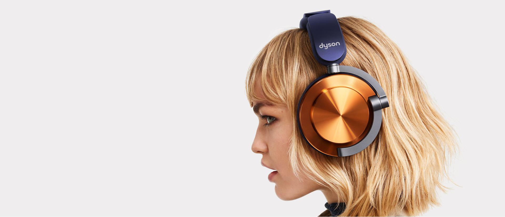 Metalik Bakır dış kapaklı Dyson OnTrac™ kulaklık takan bir modelin yandan görünümü.