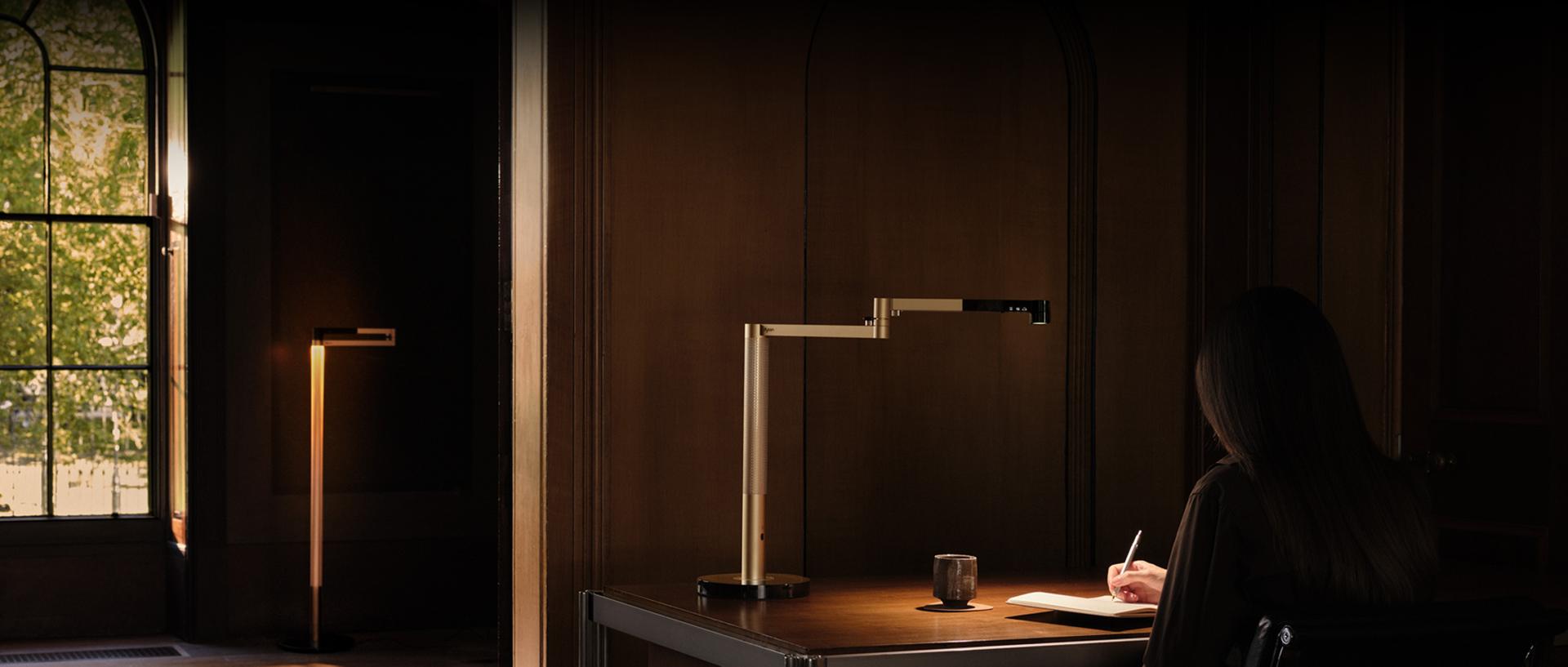 Dyson Solarcycle Morph masa lambasıyla çalışmak için masasına oturan ürün sahibi