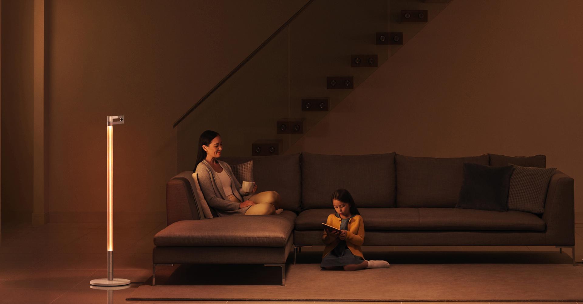 عائلة تسترخي في أجواء إضاءة محيطية هادئة مُنبعثة من وحدة الإضاءة Dyson Solarcycle Morph