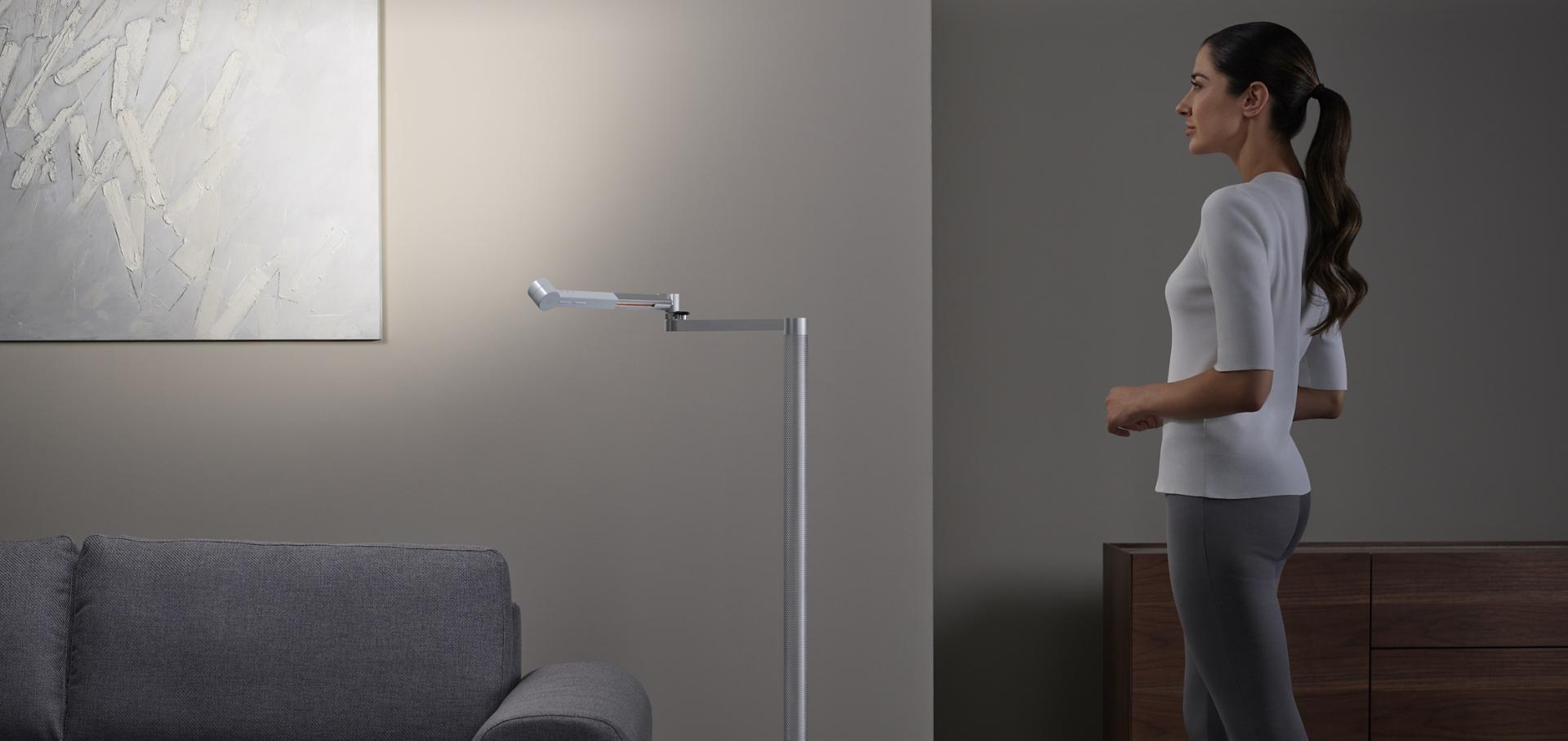 سيدة تُبدي إعجابها بالعمل الفني المُضاء بالإضاءة المميّزة القوية المُنبعثة من وحدة الإضاءة Dyson Solarcycle Morph