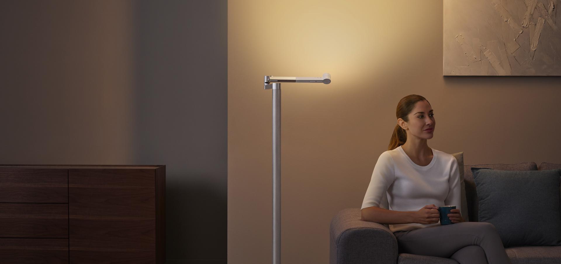 Woman relaxing under  stylish Indirect light from the Dyson Lightcycle Morph light