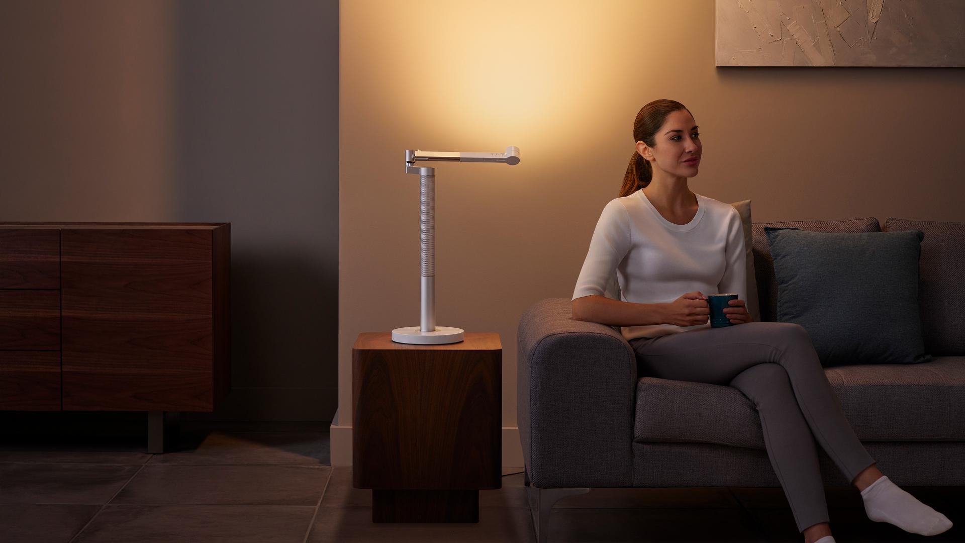 Woman relaxing under stylish Indirect light from the Dyson Lightcycle Morph light
