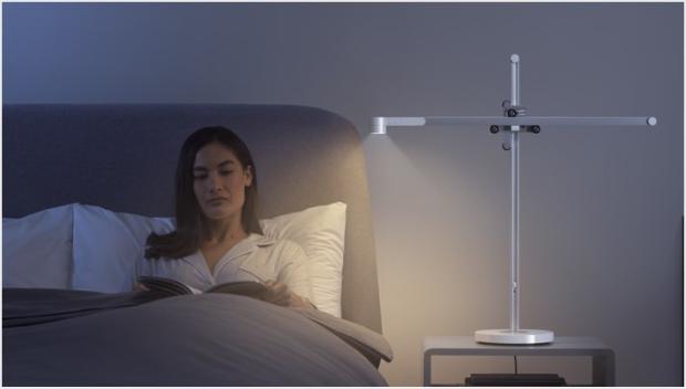 Woman relaxing in bed with the Dyson Lightcycle task light