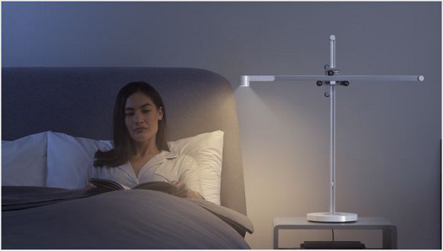 Woman relaxing in bed with the Dyson Lightcycle task light